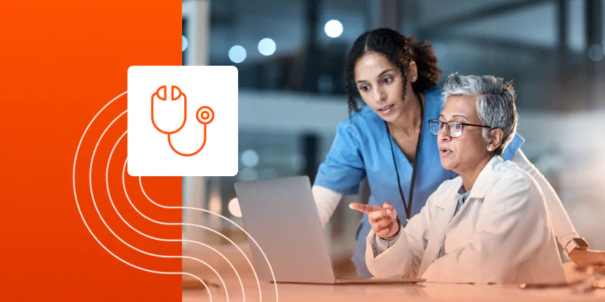 Medical staff in discussion while using laptop computer