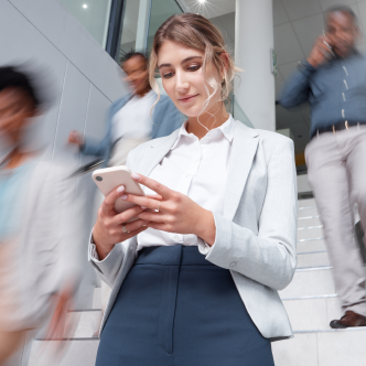 Woman using mobile phone while walking down stairs