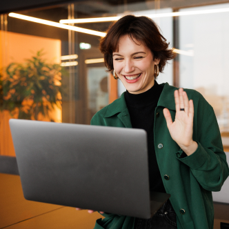 Woman waving while on laptop video chat