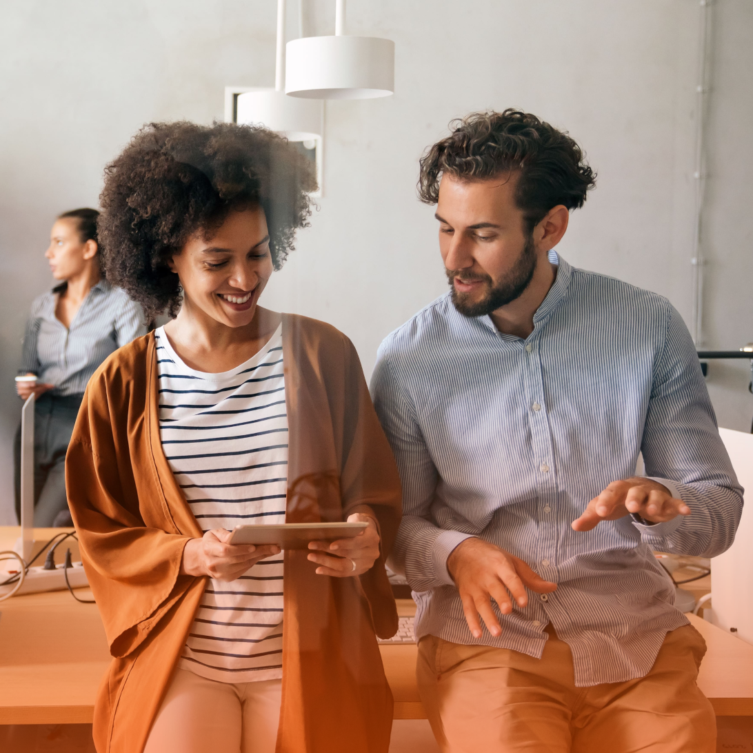 Two people looking at tablet and talking
