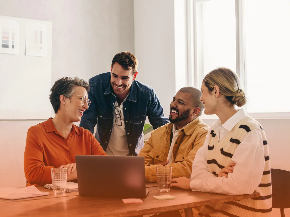 Four coworkers in discussion at table
