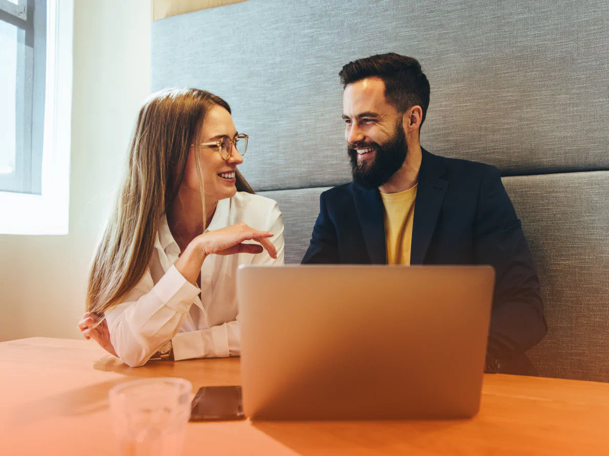 Coworkers chatting and using laptop computer