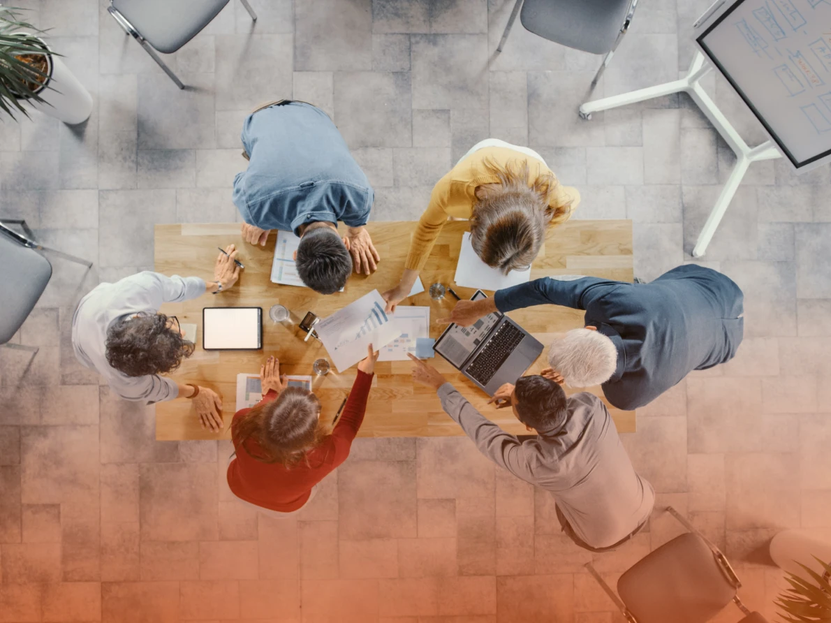 Coworkers discussing project over conference room table