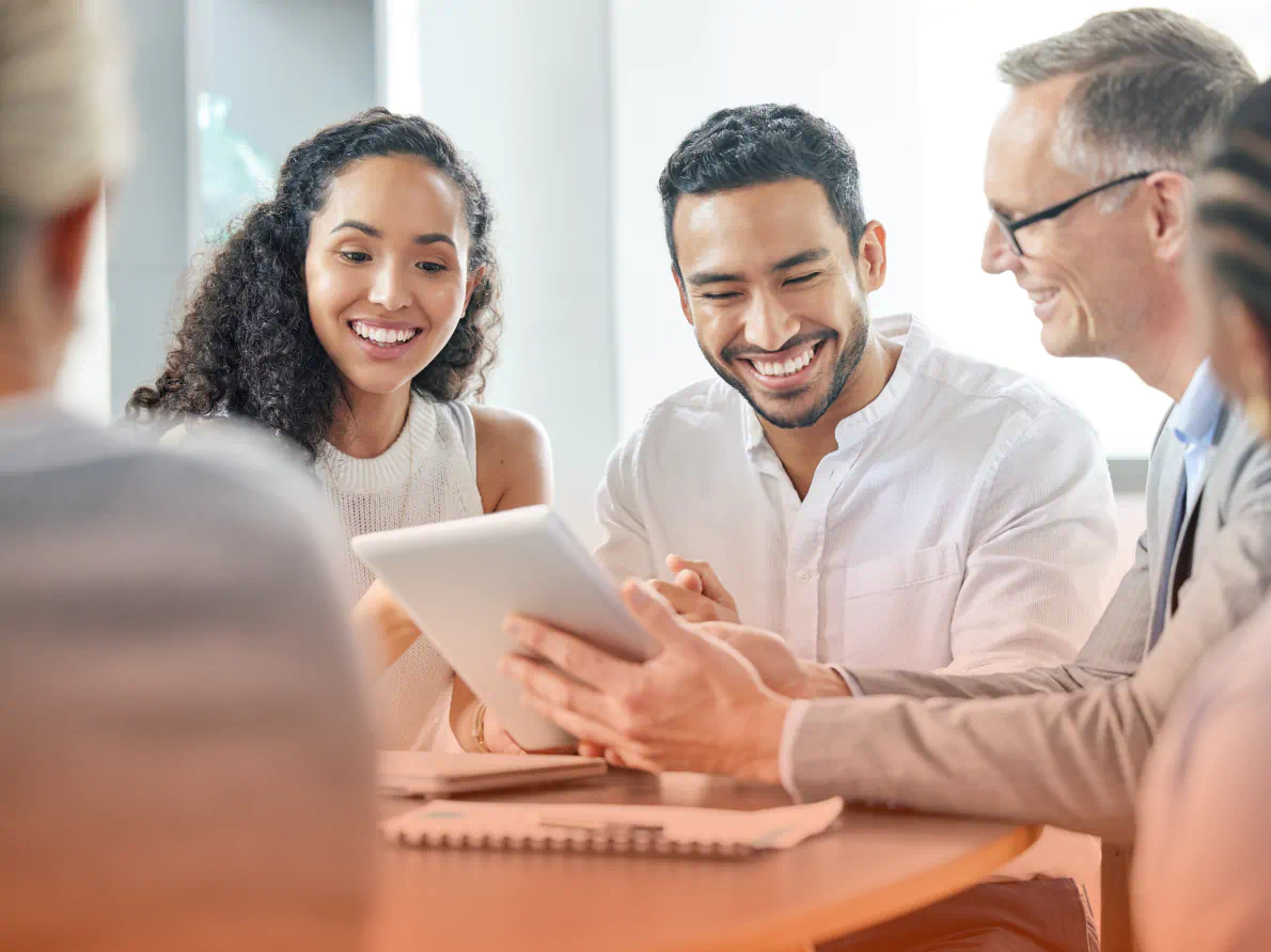 Professionals looking at tablet device and smiling